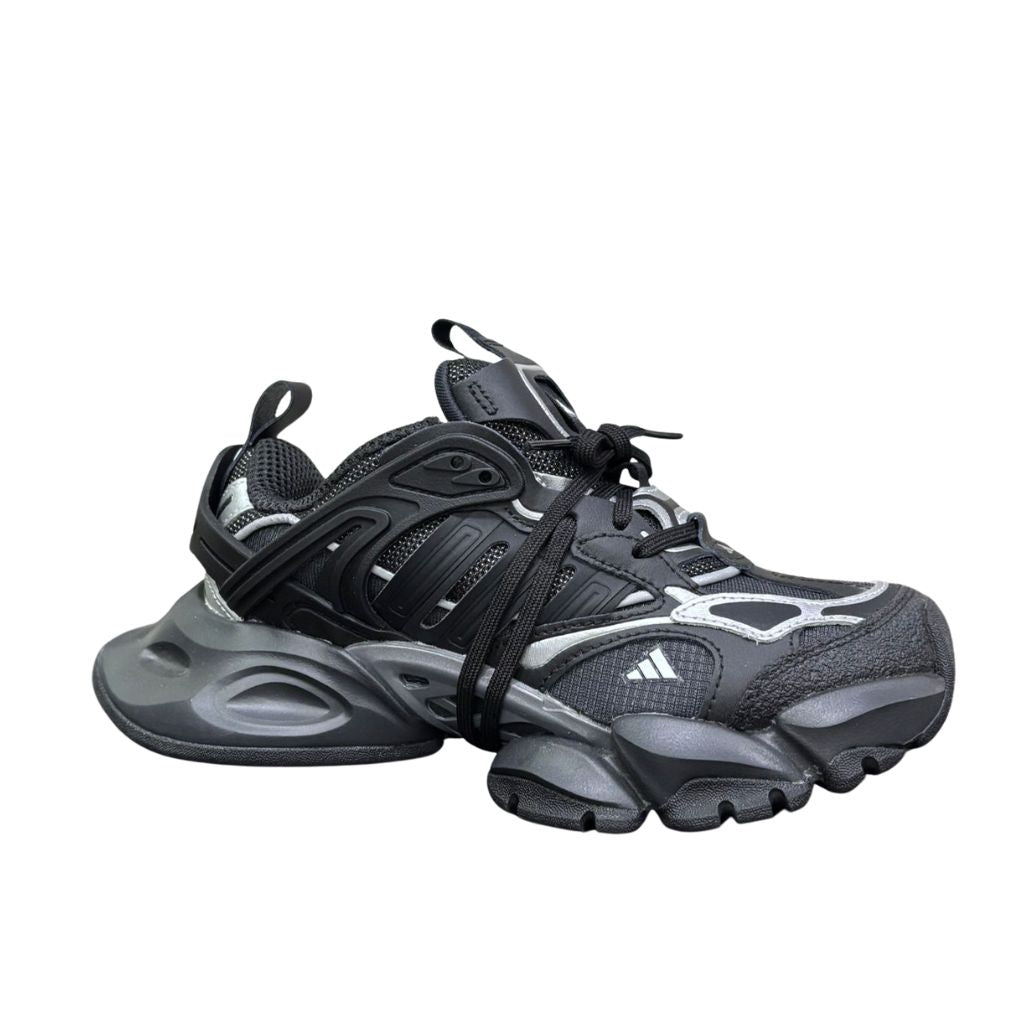 Sneaker Adidas XLG Runner Deluxe completamente nera in pelle premium, con design stratificato ispirato al running anni 2000 e suola robusta coordinata.