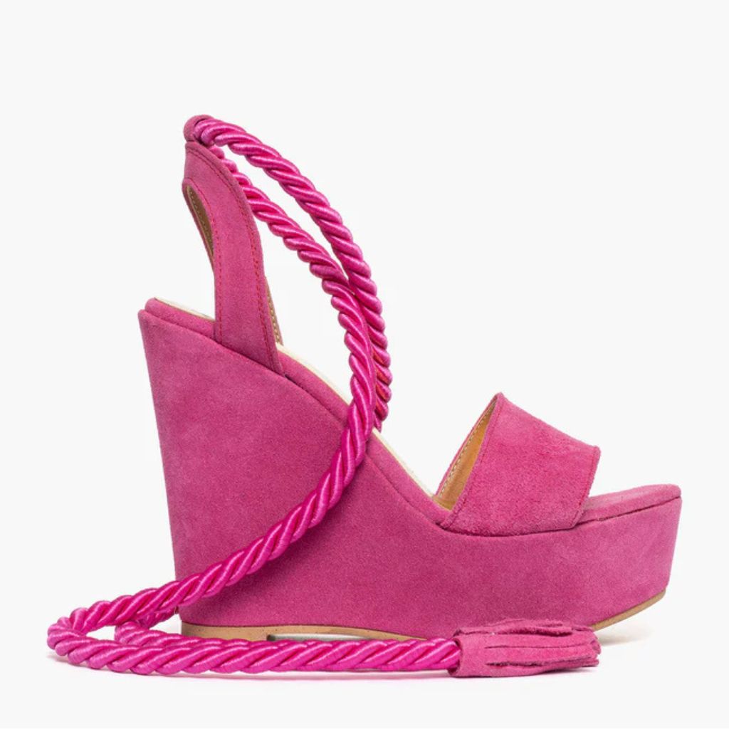 Sandalo con zeppa alta 11 cm in camoscio fucsia e lacci a corda intrecciati alla caviglia.