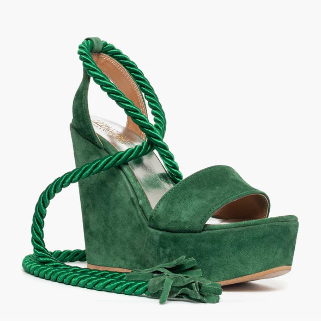 Sandalo con zeppa alta 11 cm in camoscio verde e lacci a corda intrecciati alla caviglia.