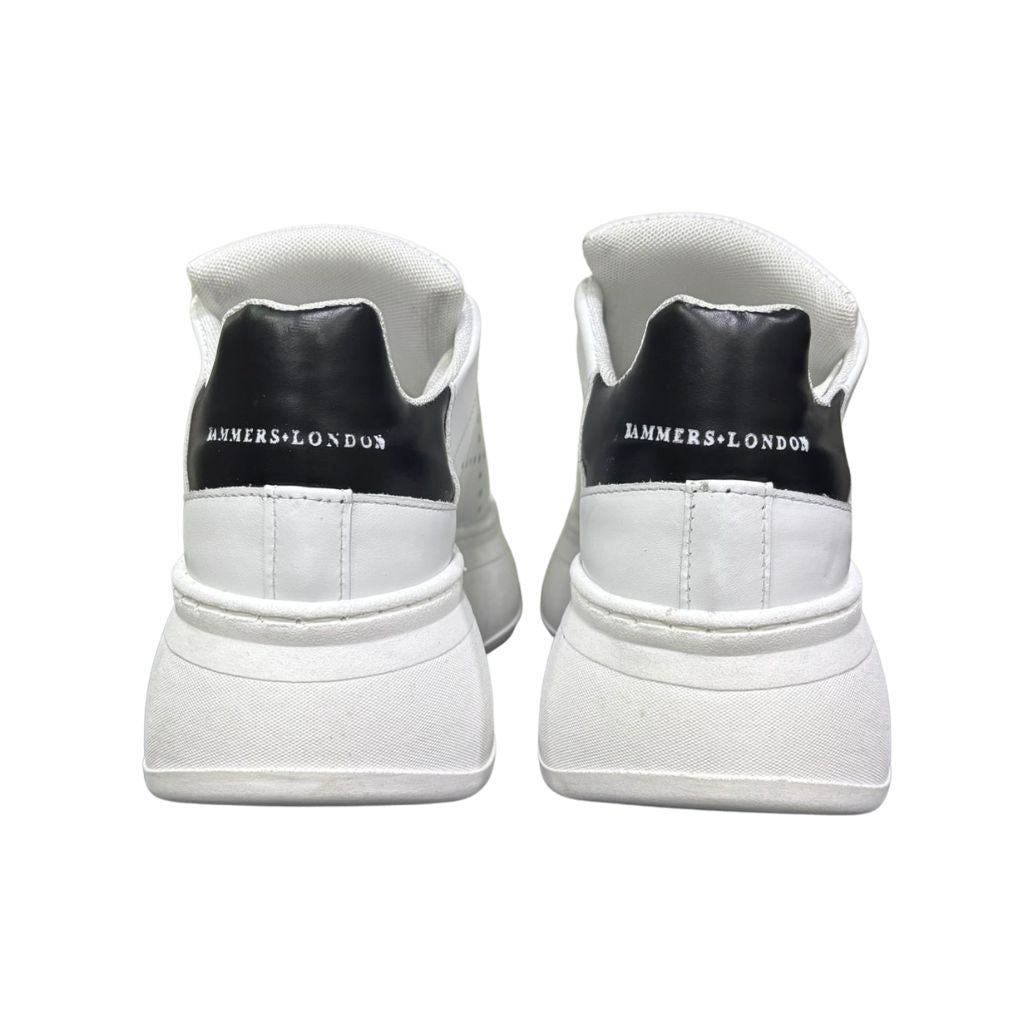 Sneaker Jammers London pelle bianca con tomaia traforata, borchietta dorata e tallone nero su maxi suola plateau.