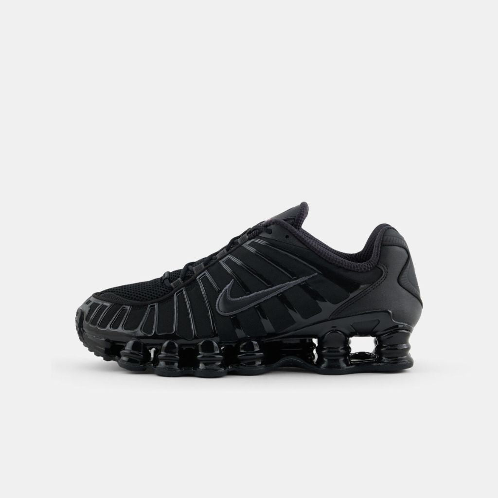 Vista laterale delle sneaker Nike Shox TL nella colorazione Black Metallic Hematite, con l'iconica suola a colonne e dettagli neri lucidi su tomaia in mesh.