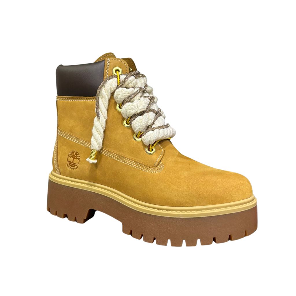 Stivale Timberland platform in nubuck color miele con lacci a corda bianchi, occhielli dorati e suola carrarmato marrone.