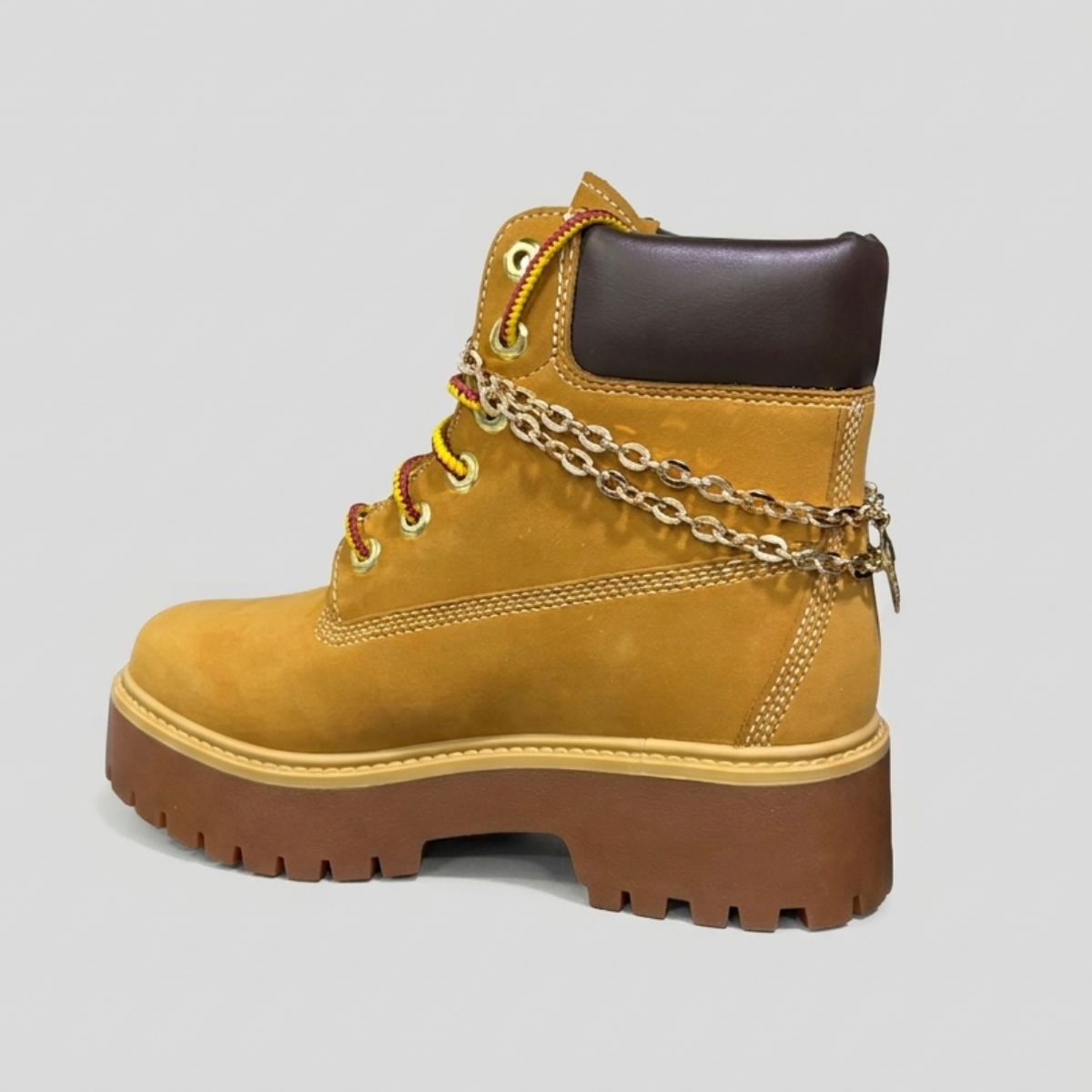 Stivale Timberland Platform Stone Street in nabuk giallo grano con catena dorata decorativa, charm e suola chunky marrone