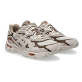 Sneaker ASICS GEL-NYC con tomaia multistrato in mesh e suede, dettagli ispirati al running d'archivio e intersuola tecnologica ammortizzata su sfondo neutro.