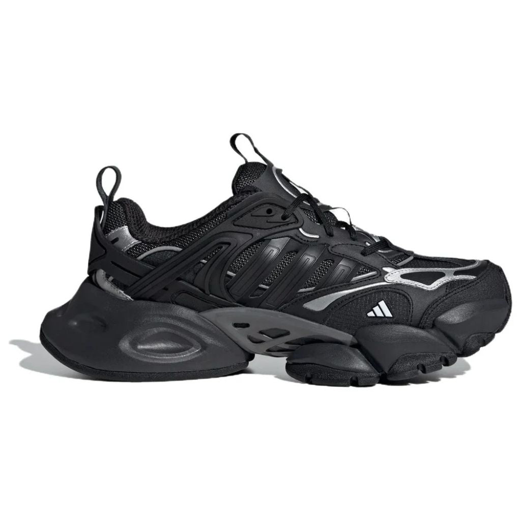 Sneaker Adidas XLG Runner Deluxe completamente nera in pelle premium, con design stratificato ispirato al running anni 2000 e suola robusta coordinata.