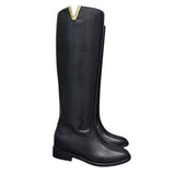 Stivale al ginocchio in pelle nera con rialzo interno 8 cm, accessorio oro e punta tonda.