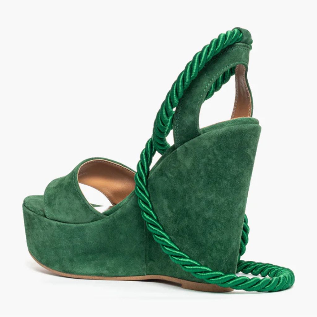 Sandalo con zeppa alta 11 cm in camoscio verde e lacci a corda intrecciati alla caviglia.