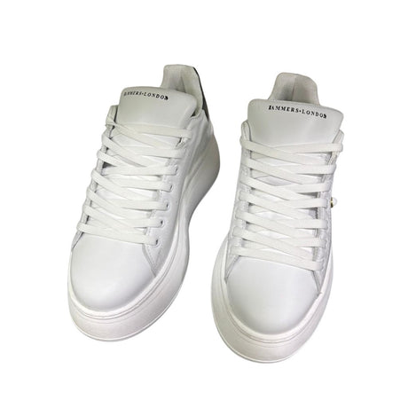 Sneaker Jammers London pelle bianca con tomaia traforata, borchietta dorata e tallone nero su maxi suola plateau.