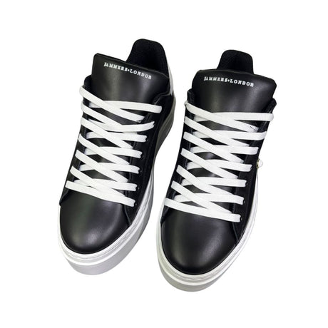 Sneaker Jammers London pelle nera con tomaia traforata, borchietta perla e tallone bianco su suola plateau.
