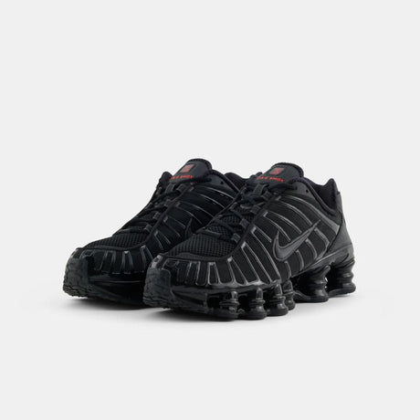 Vista laterale delle sneaker Nike Shox TL nella colorazione Black Metallic Hematite, con l'iconica suola a colonne e dettagli neri lucidi su tomaia in mesh.