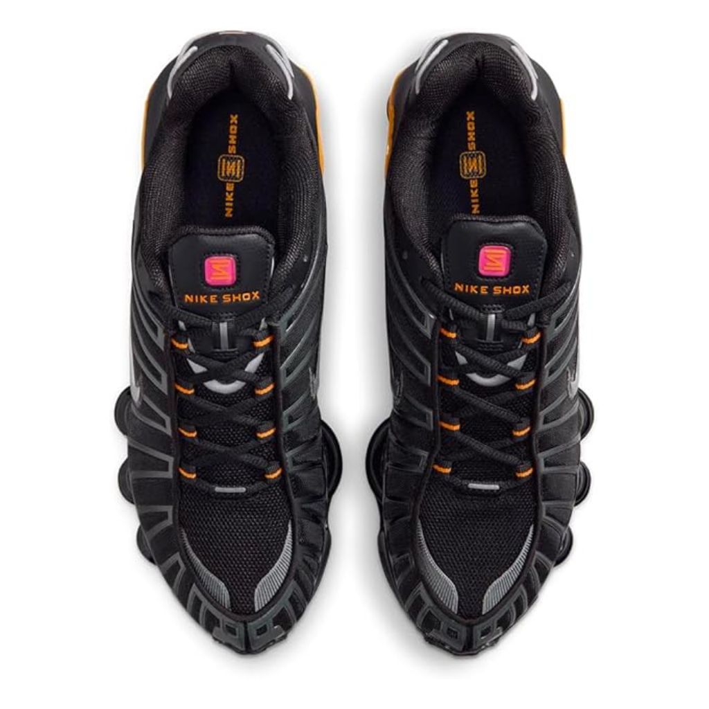 Vista laterale delle Nike Shox TL nere con colonne ammortizzanti gialle e dettagli argento metallizzato, tomaia in mesh con gabbia sintetica lucida.