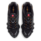 Vista laterale delle Nike Shox TL nere con colonne ammortizzanti gialle e dettagli argento metallizzato, tomaia in mesh con gabbia sintetica lucida.