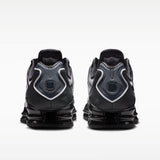 Sneaker Nike Shox TL con tomaia sfumata dal nero all'Off Noir, gabbia esterna sagomata e suola con colonne ammortizzanti integrali su fondo bianco.