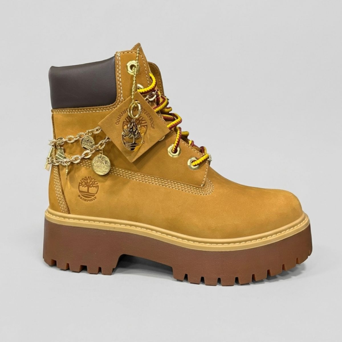 Stivale Timberland Platform Stone Street in nabuk giallo grano con catena dorata decorativa, charm e suola chunky marrone