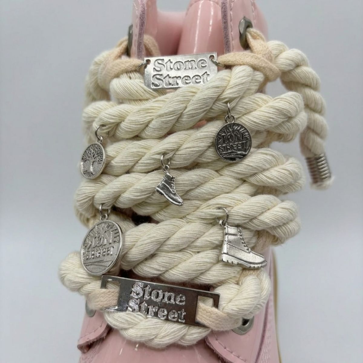 Stivale Timberland Platform Stone Street in vernice rosa cipria con lacci a corda, charm in metallo argento e suola platform