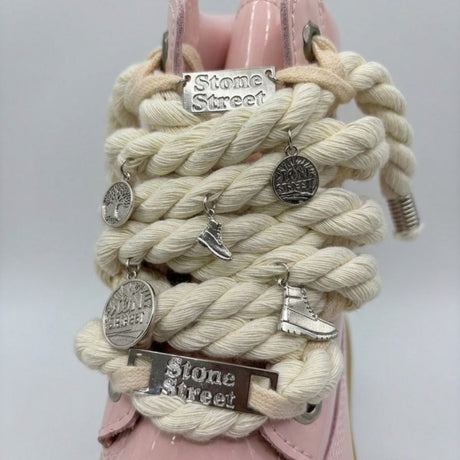 Stivale Timberland Platform Stone Street in vernice rosa cipria con lacci a corda, charm in metallo argento e suola platform