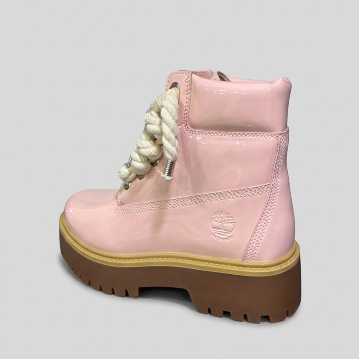 Stivale Timberland Platform Stone Street in vernice rosa cipria con lacci a corda, charm in metallo argento e suola platform