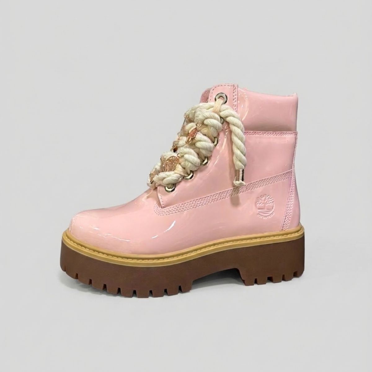 Stivale Timberland Platform Stone Street in vernice rosa cipria con lacci a corda intrecciata e charm in metallo rose gold su suola platform 