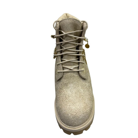 Stivaletto stringato Timberland Heritage 6-Inch in nabuk scamosciato beige chiaro con filo di perle, catena dorata e ciondoli pendenti.