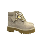 Scarponcino Timberland beige in suede con lacci a corda, charm dorati e suola platform