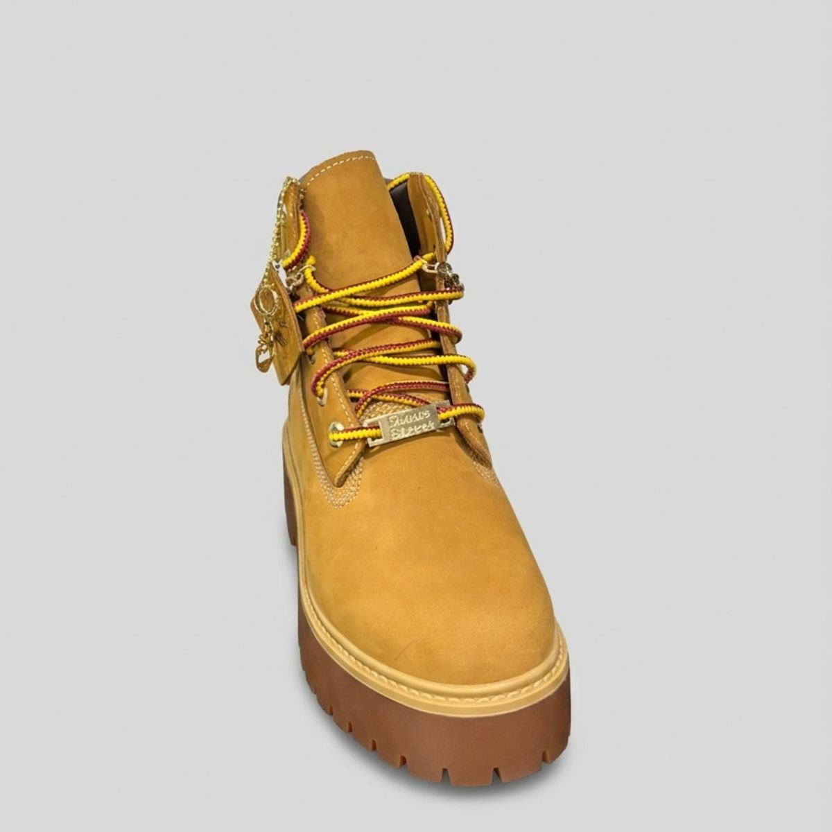 Stivale Timberland Platform Stone Street in nabuk giallo grano con catena dorata decorativa, charm e suola chunky marrone