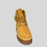 Stivale Timberland Platform Stone Street in nabuk giallo grano con catena dorata decorativa, charm e suola chunky marrone