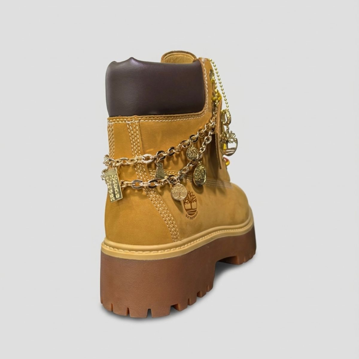 Stivale Timberland Platform Stone Street in nabuk giallo grano con catena dorata decorativa, charm e suola chunky marrone