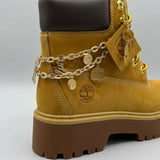 Stivale Timberland Platform Stone Street in nabuk giallo grano con catena dorata decorativa, charm e suola chunky marrone