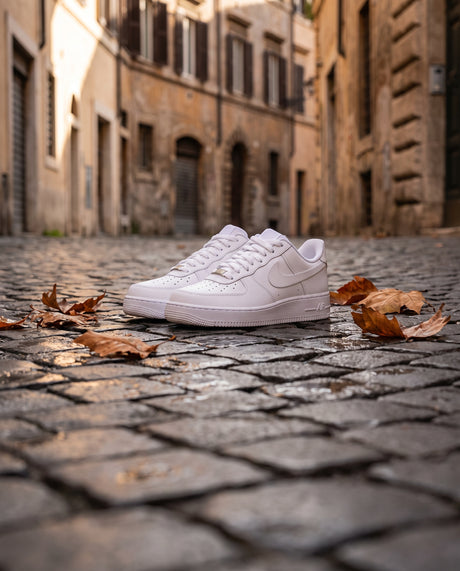 Nike Air Force 1 bianche su sampietrini bagnati in autunno