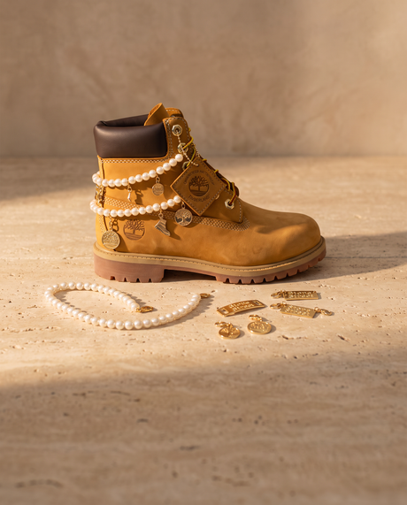 Timberland 6-Inch Wheat con fili di perle e charms oro, accanto i pezzi del kit fai da te
