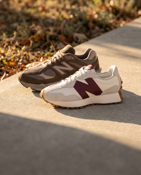 New Balance 9060 Mono Cortado e 327 Burgundy su un gradino di cemento al sole